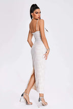 Woman wearing a white evening gown with a high slit on a white background